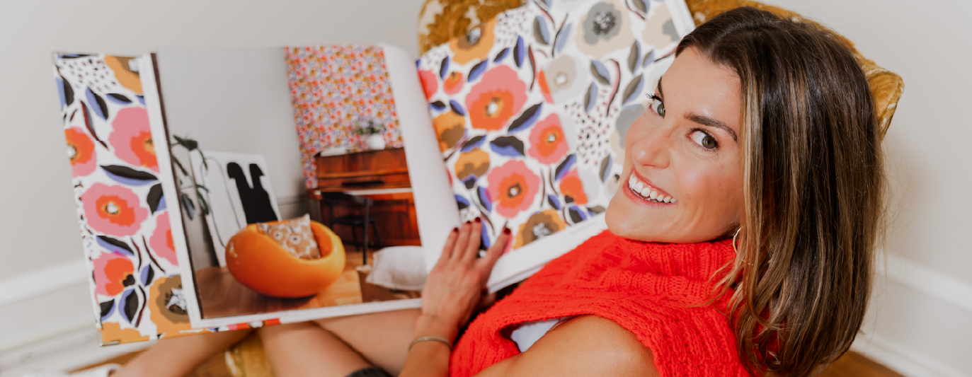 Designer smiling while flipping through a floral pattern book.