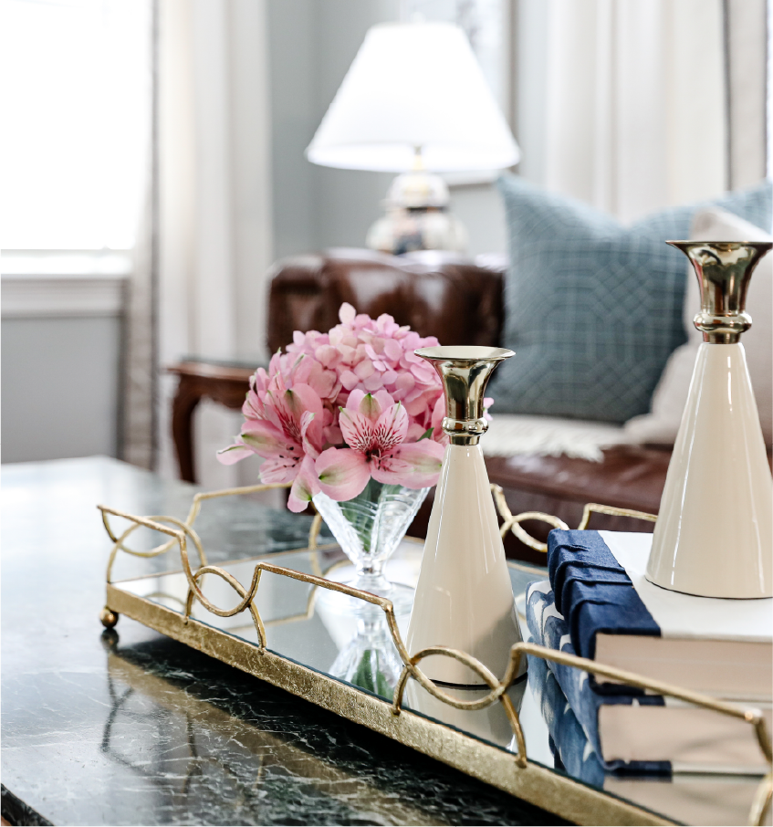 pink-flowers-gold-tray-styling Elegant coffee table styling with pink hydrangea and alstroemeria flowers in glass vase on gold mirrored tray with white ceramic candlesticks