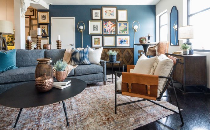 teal-accent-wall-showroom Contemporary showroom with deep teal accent wall, eclectic gallery arrangement, gray sofas, and leather sling chair